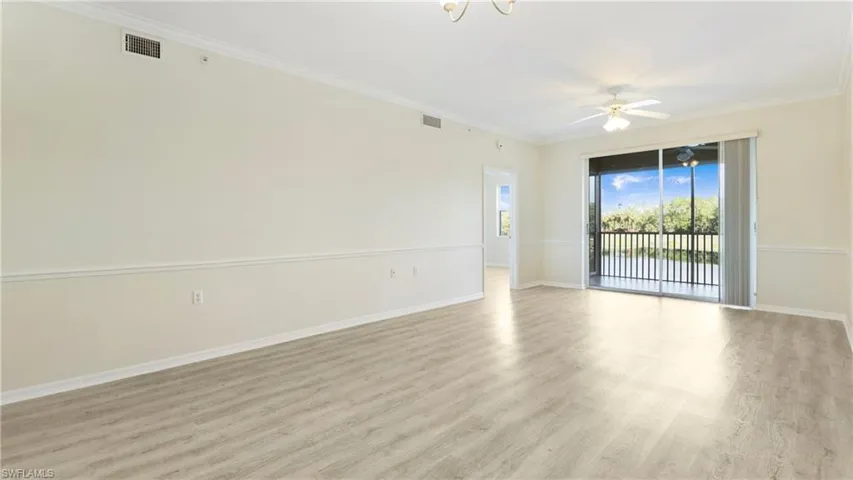 Unfurnished room with light wood-style floors, ornamental molding, and a ceiling fan