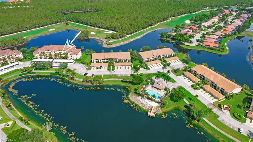 Aerial overview of property's location with a heavily wooded area and a nearby body of water