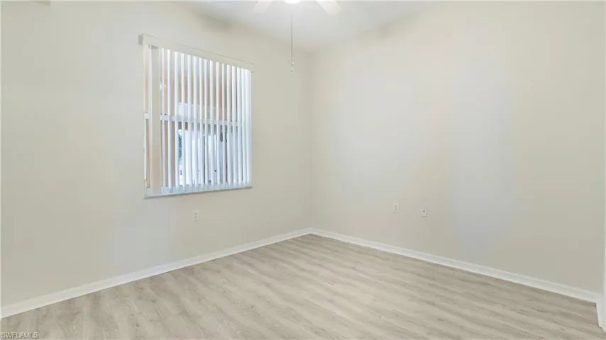 Spare room with wood finished floors and a ceiling fan