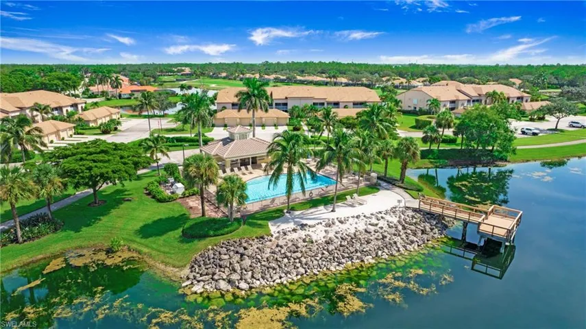 Aerial perspective of suburban area featuring a large body of water and a pool