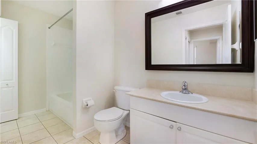 Full bathroom with vanity, bathing tub / shower combination, and light tile patterned floors