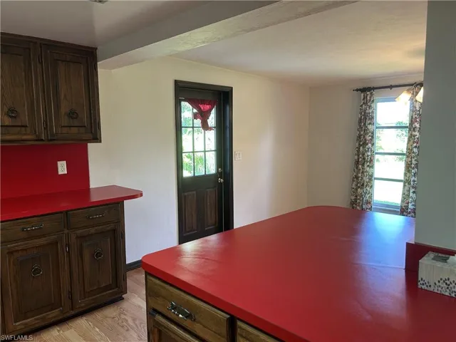 Kitchen has breakfast bar  is large, exterior door to back yard.