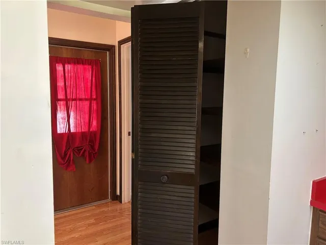 View of spacious shelved reach in pantry in kitchen.  Door to garage.  On the left there is a cool custom closet for brooms ect.