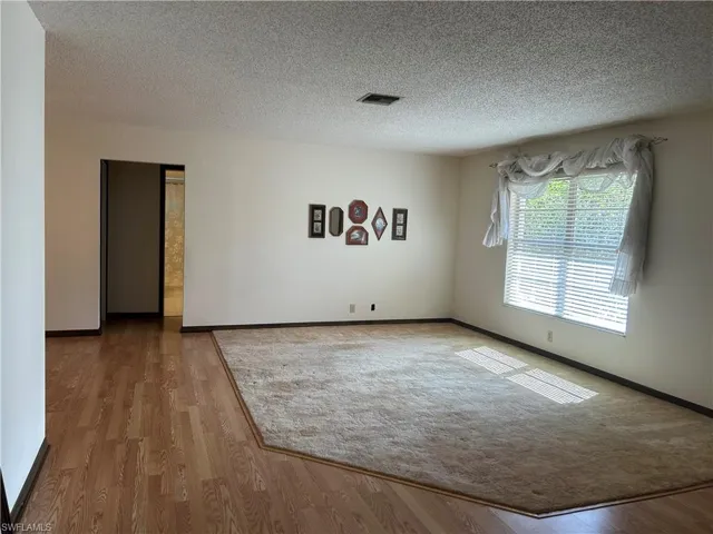 Spare room featuring a textured ceiling and light wood-type flooring