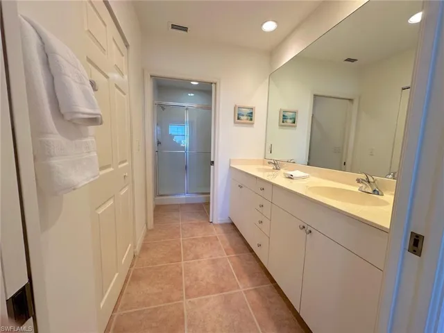 Large master bath with double sinks and separate room for shower and toilet.