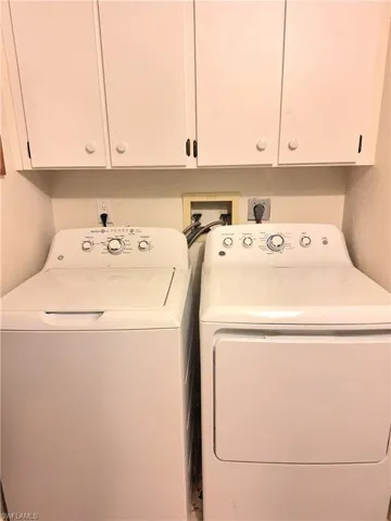 Clothes washing area with separate washer and dryer and cabinets