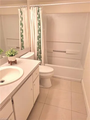 Full bathroom with tile patterned floors, vanity, and shower / bath combo