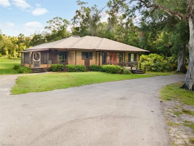 Ranch-style home with covered porch, a front yard, and asphalt driveway