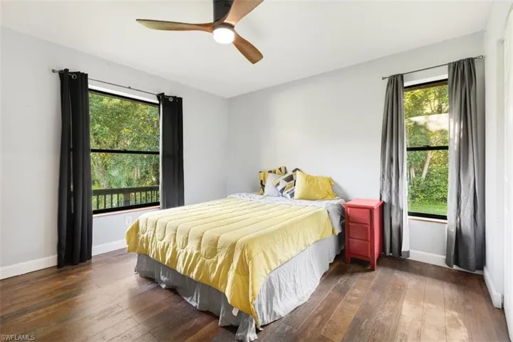 Bedroom with multiple windows, wood-type flooring, and baseboards