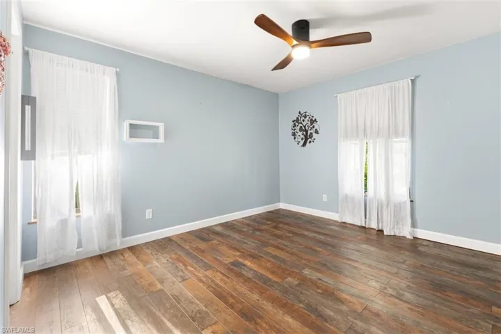 Spare room with hardwood / wood-style floors, ceiling fan, and baseboards