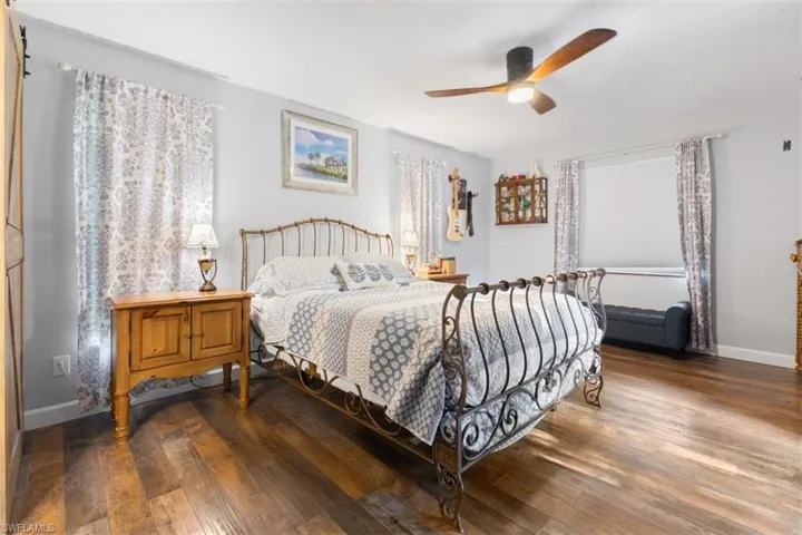 Bedroom with wood finished floors, baseboards, and a ceiling fan