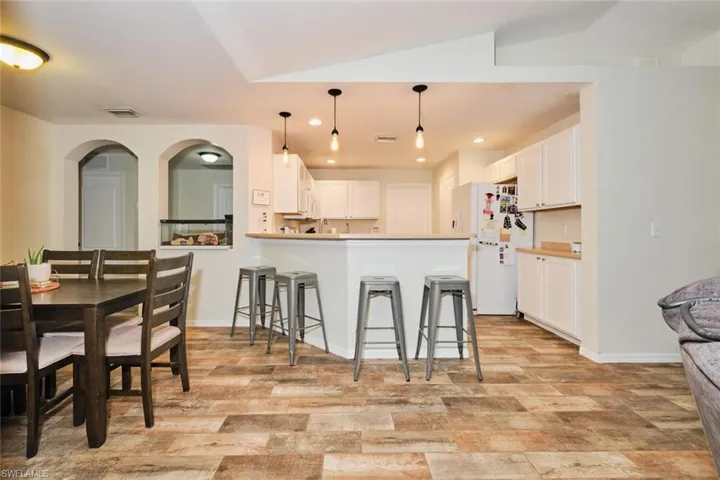 Kitchen featuring hanging light fixtures, white cabinet