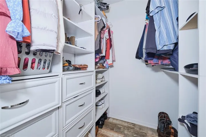 Walk in closet featuring built in drawers and shelving