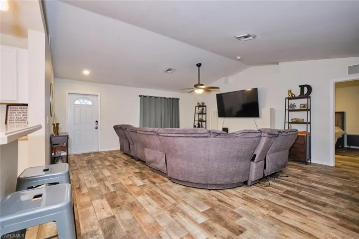 Living room with  ceiling fan, and lofted ceiling