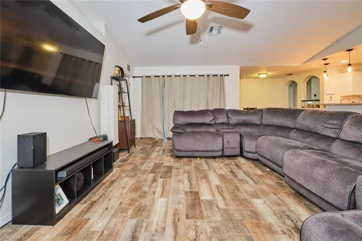 Living room featuring vaulted ceiling and ceiling fan