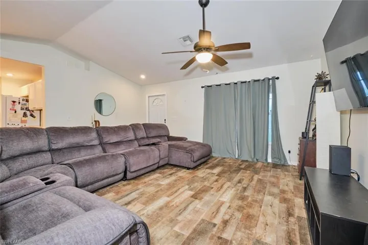 Living room with ceiling fan, vaulted ceiling