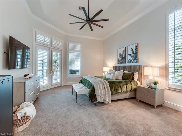 Ground level bedroom with ornamental molding, access to exterior, carpet, ceiling fan, and french doors Lanai, includes en-suite and kitchenette.