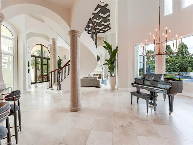 Entryway with a high ceiling, french doors, plenty of natural light, stairway, and a fireplace