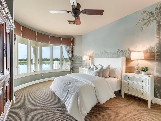 Upstairs carpeted bedroom featuring a water view and a ceiling fan, includes en-suite.