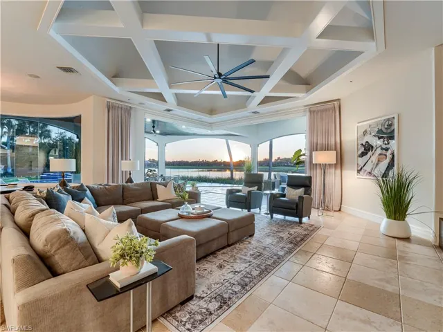 Living room with coffered ceiling, a ceiling fan, and beam ceiling