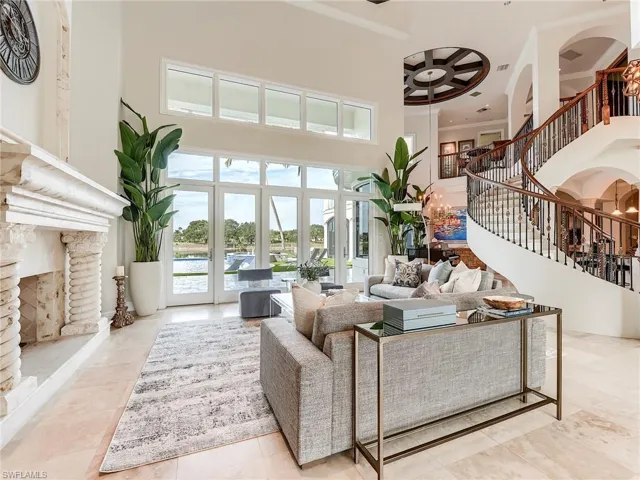 Living area with stairway, a fireplace with raised hearth, ornamental molding, a high ceiling, and recessed lighting