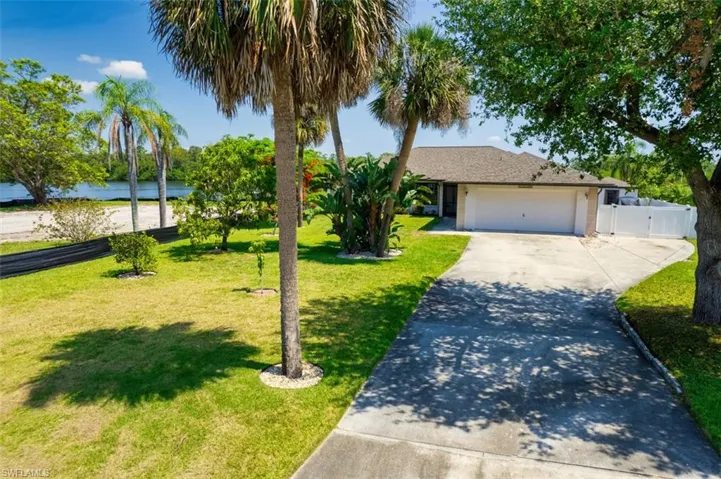 Ranch-style home featuring concrete driveway, an attached garage, a gate, and stucco siding