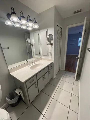Bathroom with vanity, tile patterned flooring, and a closet