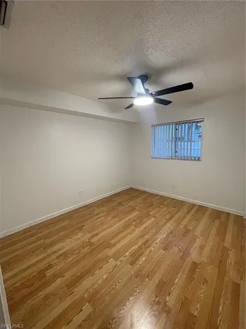 Empty room with a textured ceiling and light wood-style flooring