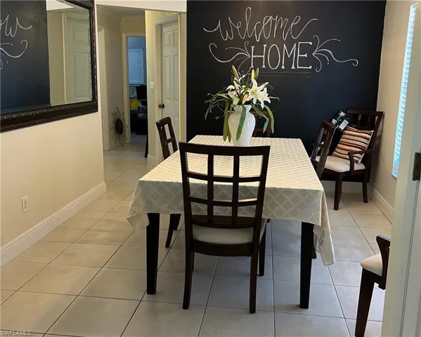 Dining room featuring light tile patterned flooring, crown molding, and a textured ceiling