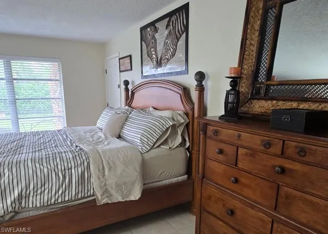 Bedroom with a textured ceiling and light tile patterned floors