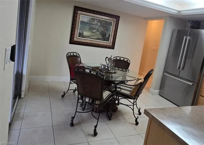 Dining area with light tile patterned flooring and baseboards