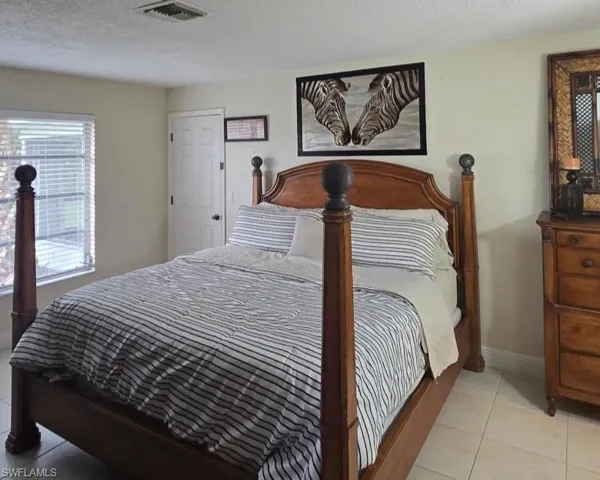 Bedroom with light tile patterned floors and a textured ceiling