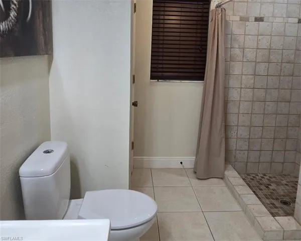 Full bathroom with light tile patterned floors and a stall shower