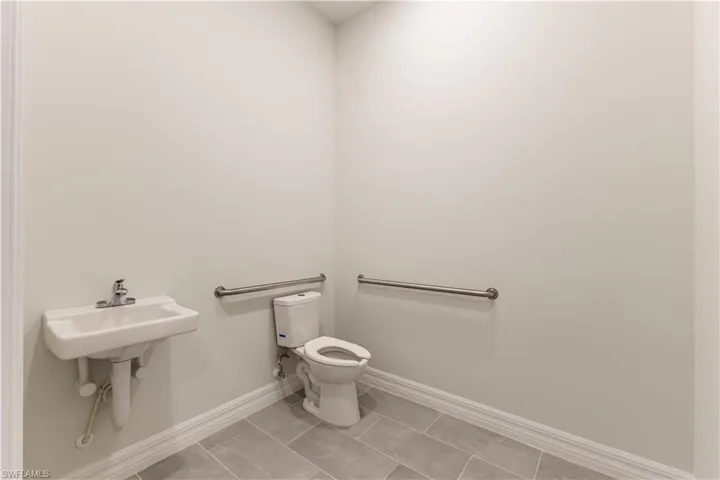 Bathroom featuring baseboards and light tile patterned floors