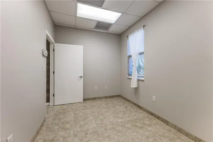 Unfurnished room with a paneled ceiling and light tile patterned floors