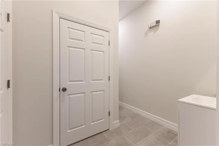 Hall featuring baseboards and light tile patterned floors