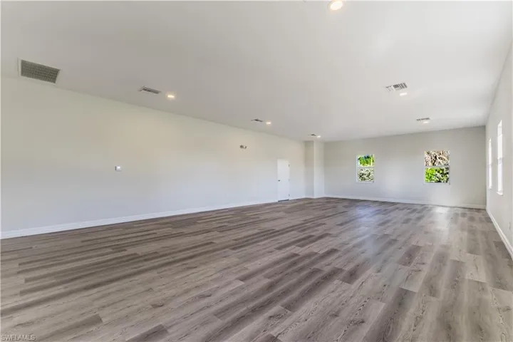Unfurnished room with wood finished floors and recessed lighting