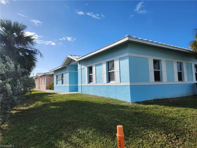 View of side of home featuring a yard