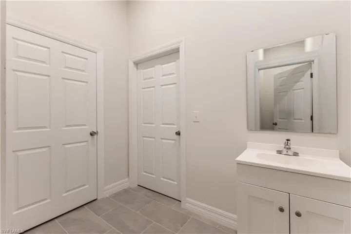 Bathroom with light tile patterned flooring and vanity