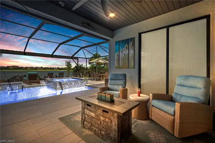 Patio terrace at dusk with a pool with connected hot tub and a lanai