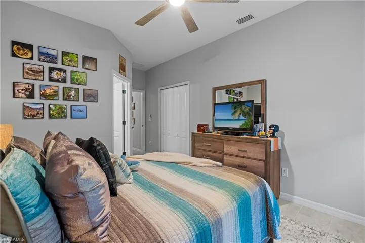 Bedroom featuring a closet, visible vents, baseboards, ceiling fan, and lofted ceiling