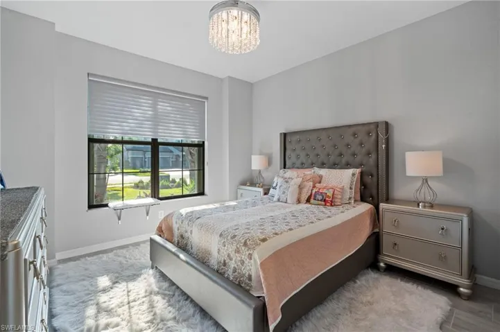 Bedroom featuring baseboards and a notable chandelier