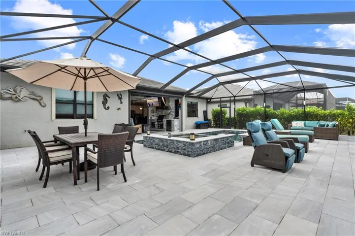 View of patio featuring an outdoor pool, glass enclosure, outdoor dining space, outdoor lounge area, and an in ground hot tub