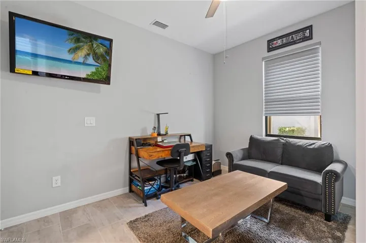 Living room featuring baseboards, visible vents, and ceiling fan