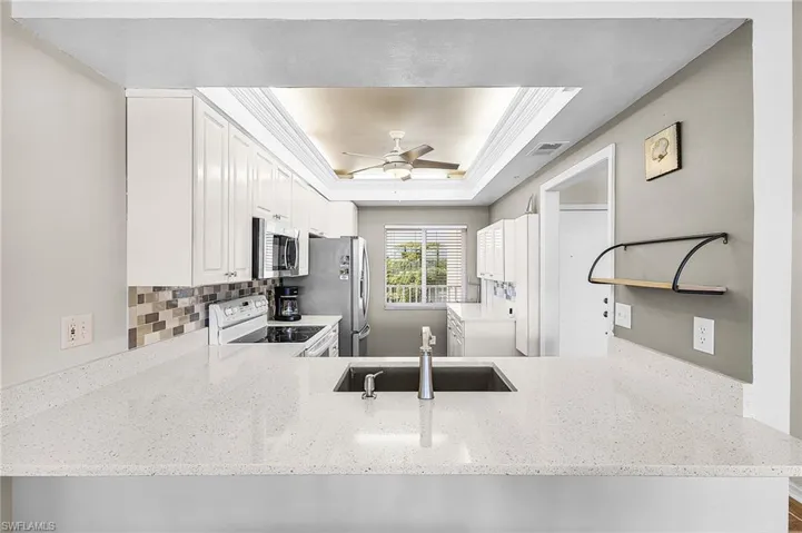 Updated kitchen w/quartz countertop, deep bowl sink, new disposal, gooseneck faucet, tiled backsplash and extra cabinets galore!