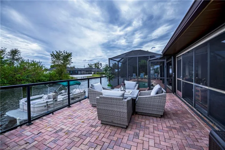 View of patio / terrace with an outdoor living space, a water view, and glass enclosure