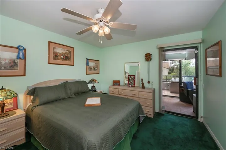 Carpeted bedroom with access to outside and ceiling fan