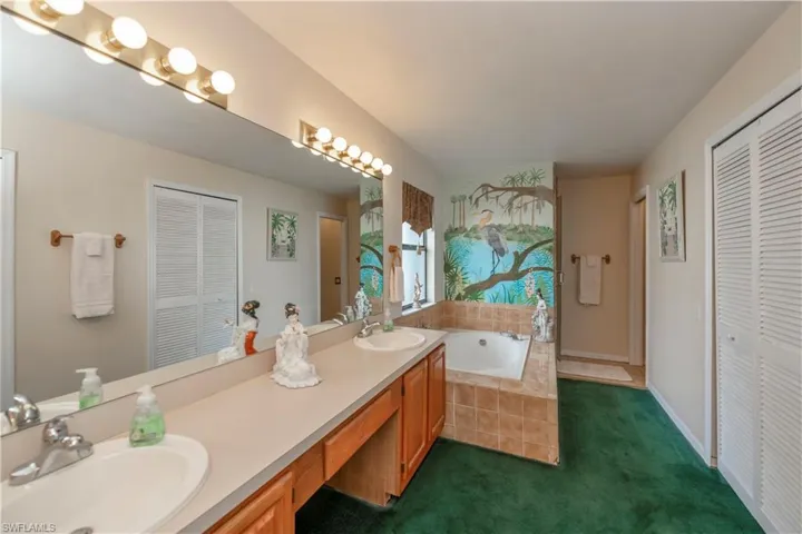 Bathroom with vanity and tiled tub