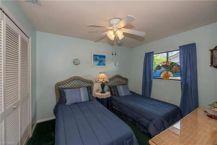 Carpeted bedroom featuring a closet and ceiling fan