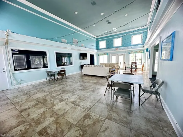 Spacious interior featuring large format tile flooring and a vaulted ceiling